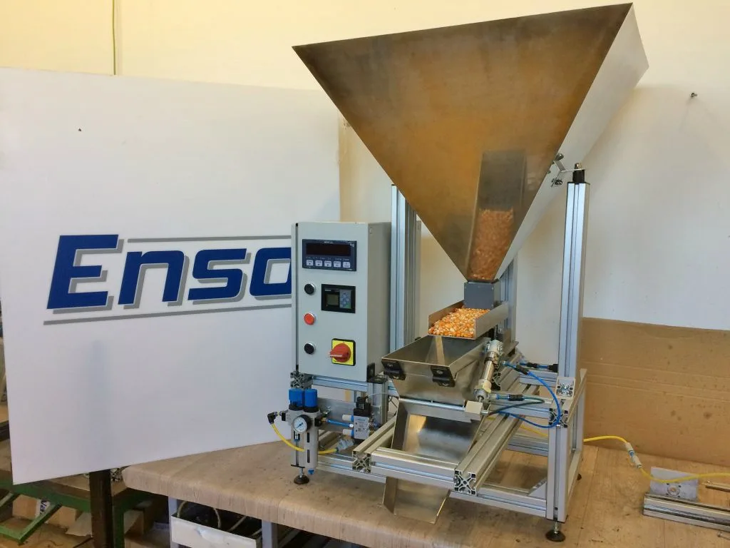 The DOZA-K machine with stainless steel hopper, vibratory trough and scale indicator while dosing corn
